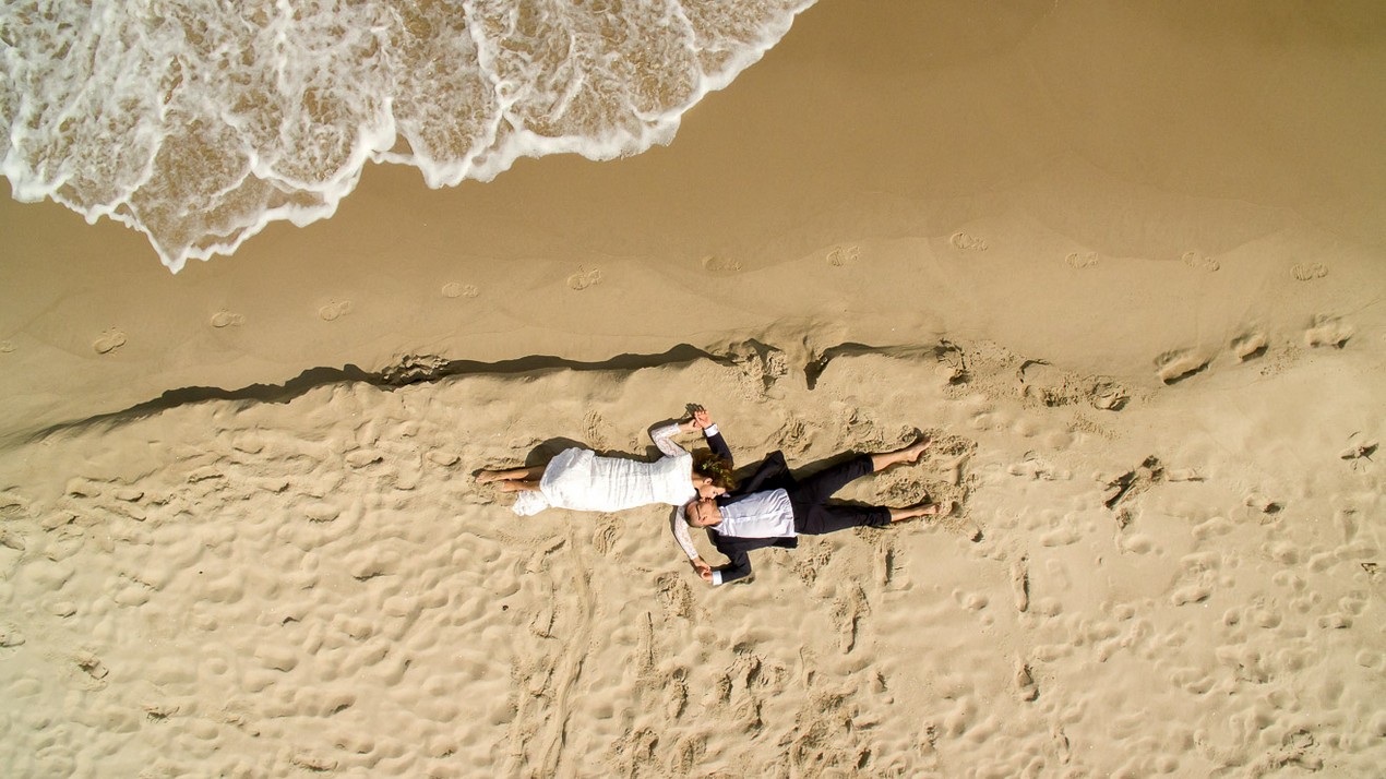 para młoda leży na piasku na plaży