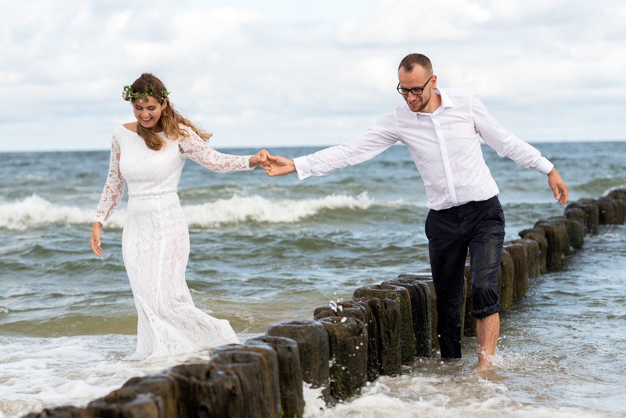 Para młoda idzie w morzu podcza sesji ślubnej